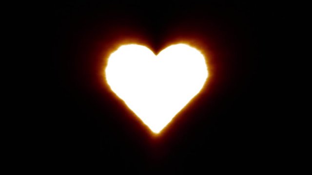 Shiny fire heart icon fly in center flickers with rgb spectrum colors and flies away with light trail. Super bright white symbol in motion isolated on black background. 4k 60 fps footage.
