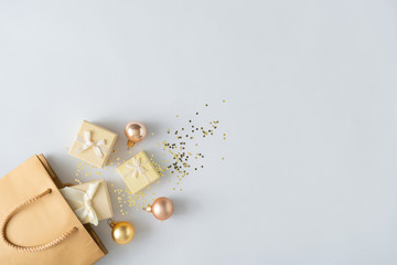 Gift shopping bag with presents and Christmas ball decoration and solden glitter. Holiday sale...