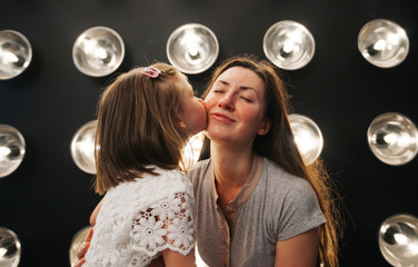 Mother and child daughter kissing and hugging