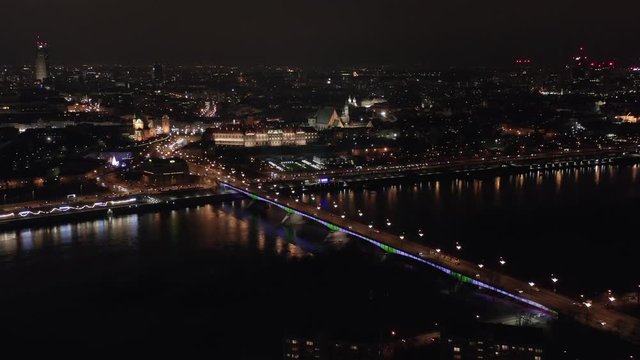 Aerial view of the bridge in the old city, panoramic view of the royal palace and the trafficway on the bridge. Warsaw, Poland. 14. January. 2020. Drone shot on a night bridge with illumination.