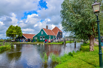 Zaanse Schans, Holland, August 2019. Northeast Amsterdam is a small community located on the Zaan River. View of the pretty wooden houses of the village, mainly green in color. Cloudy day.