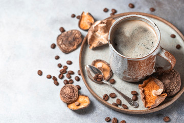 Mushroom coffee, a ceramic cup, mushrooms and coffee beans on stone concrete background. New Superfood Trend.