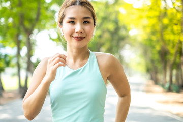 Running Asian woman. Female Runner Jogging during Outdoor Workout in a Park. Asian woman running in garden. Her morning exercise.