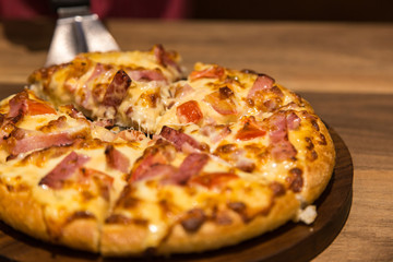 hot cheese piuzza in dinner light on wood table