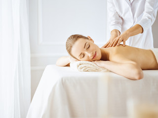 Obraz na płótnie Canvas Beautiful woman enjoying back massage with closed eyes