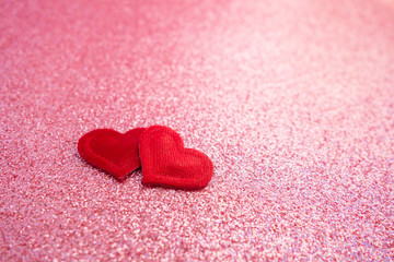 Two small red handmade hearts on bright pink bokeh background. Happy valentines day. Space for text. Selective focus.