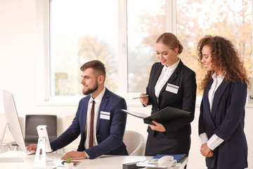 Male and female receptionists working in office
