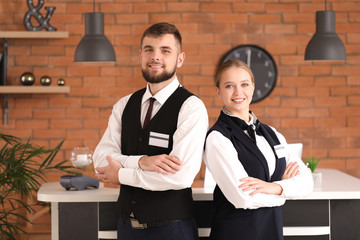 Male and female receptionists near desk in hotel