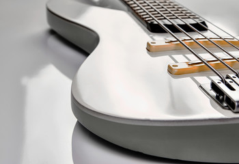 White bass guitar details on a white background with copy space - obrazy, fototapety, plakaty
