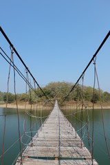 Old wooden bridge built to walk across the lake in the park.
