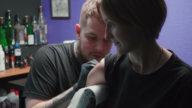 Tattooer getting tattoo of snake in salon