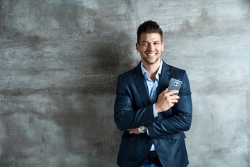 Happy young businessman with mobile phone