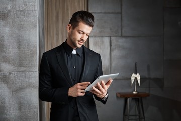 Portrait of good-looking young catholic priest © nyul