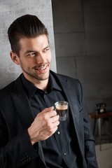 Young handsome businessman drinking coffee