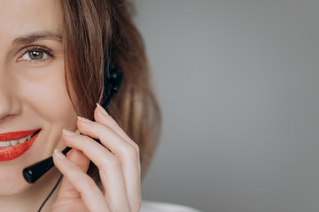 Portrait of happy smiling cheerful young support phone operator in headset showing copyspace area or something, isolated over background.