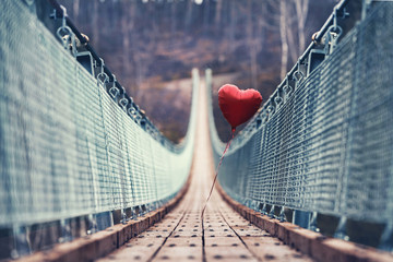 roter schwebender Ballon auf der Hängebrücke