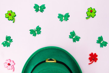 March 17 is the feast of St. Patrick. Green felt hat and shiny paper clover leaves on a white...