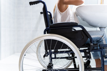 Detail of a wheelchair with a girl in a bathroom