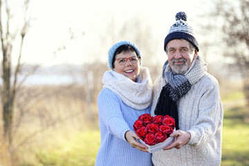 lachendes glückliches Paar mit roten Rosen