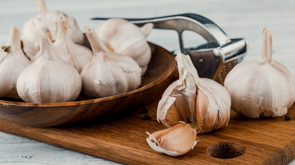 Garlic on a rustic table in a wooden bowl. Fresh peeled garlic.