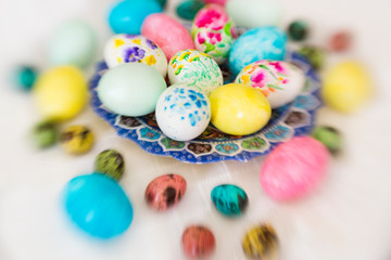 Colorful hand painted with watercolor easter eggs with painting of flowers on lace tablecloth