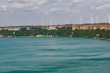 Rocky beach. Wind generators. Green electricity.  Black Sea. Cape Kaliakra, Bulgaria. - 319741437