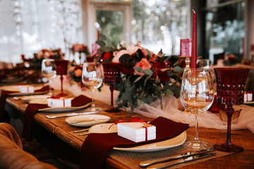Beautiful, decorated table with flowers and red candles. Luxury Christmas evening or wedding party decoration.