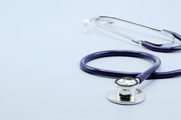 Close up on chest piece of stethoscope for doctor checkup on light blue background with copy space,...
