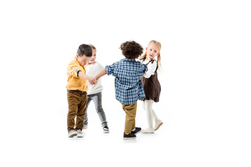 adorable multicultural children holding hands and playing isolated on white