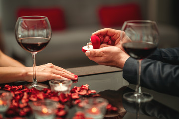 A couple having a romantic dinner and a suprise proposal in a elegance restaurant with beautiful decoration. Romance and Valentines day concept.  - obrazy, fototapety, plakaty