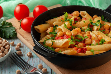 Fototapeta na wymiar Italian pasta with chickpeas, spices and tomatoes - closeup