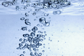 Pour water into glass on white background.