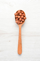 Hazelnut in a wooden spoon.Top view. Free space for your text.