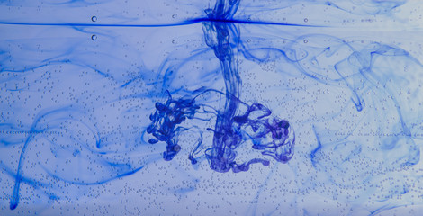 blue ink poured into water. white background