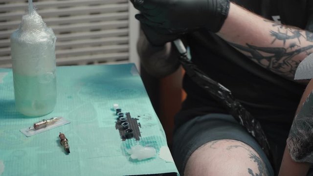 Video of man doing dark tattoo of snake for woman