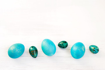 Easter background.  Blue easter eggs on a white wooden background close-up, top view, copy space