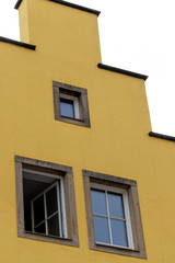 Fototapeta na wymiar windows on square shaped yellow building 