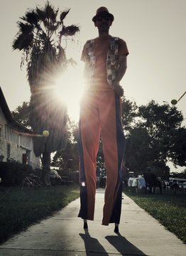 Man Walking On Stilts In Park