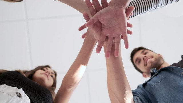 Video of close-up happy diverse adult business people joining hands together. 