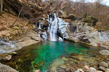 Beautiful winter waterfall surrounded by ice, shot with long exposure and silk water effect, in the...