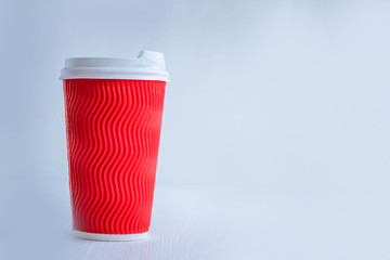 Red paper coffee cup with white plastic lid. Hot takeaway coffee. Delicious morning coffee on the go. Cup of coffee on a white background. Processing.