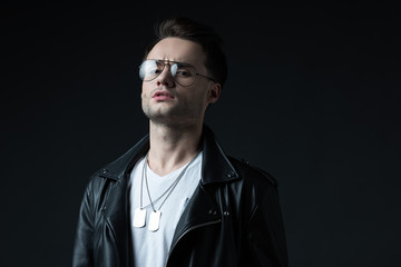 serious stylish brutal man in biker jacket isolated on black