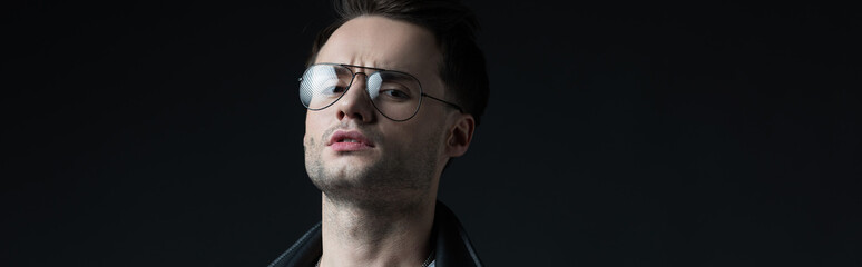 serious stylish brutal man in eyeglasses isolated on black, panoramic shot