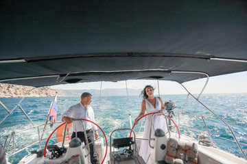 Family wedding couple on a sea voyage on a sailing yacht.