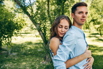 Beautiful couple in love dating outdoors at the park on a sunny day. Happy couple in love embracing each other, looking with love having eyes full of happiness. Date day. Family time
