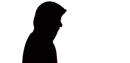 dark male silhouette in casual sportswear with a hood, figure of a guy hiding his face, concept of...