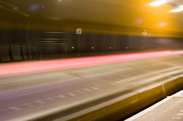 Fototapeta na wymiar Abstract blur of train by motion at night at station Arnhem south, Netherlands