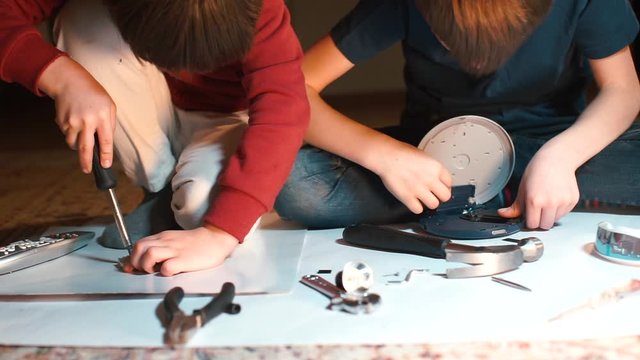 Two schoolchildren play with a constructor on the floor at school. 