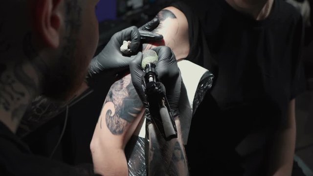 Video of doing tattoo of snake for woman in studio