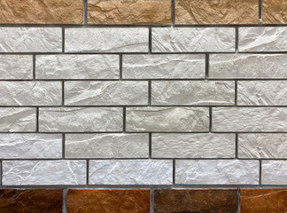 Obraz premium Textured white and brown brick wall with stone texture and gray seams. decorative tiles for wall decoration. Artificial stone. Background, texture
